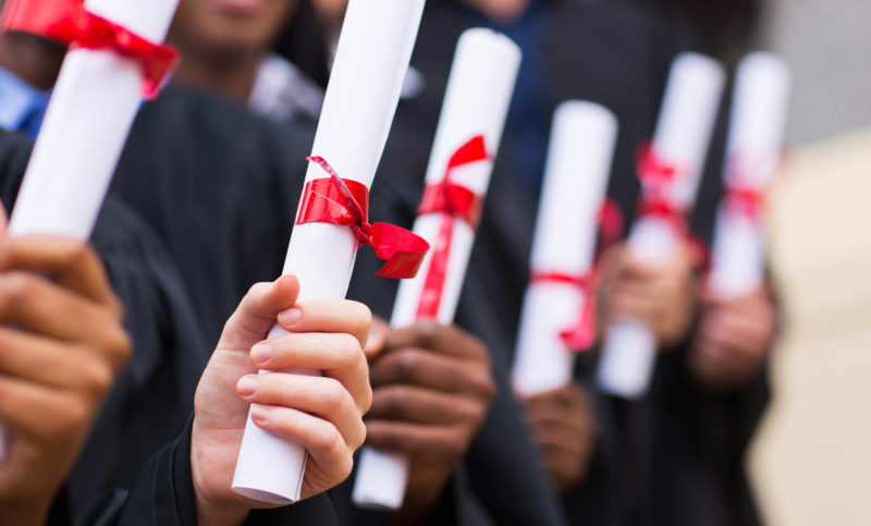 group of graduates holding diploma