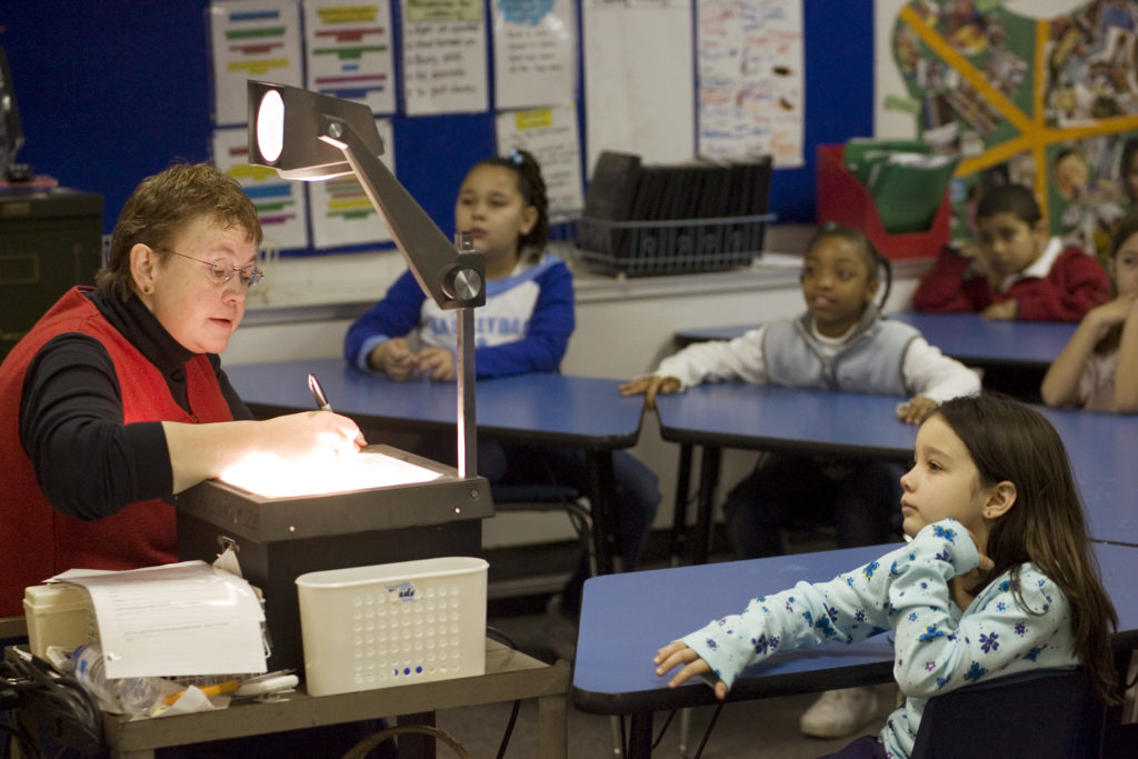 teacher at overhead w students looking on