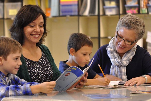 teacher and paraeducator with students