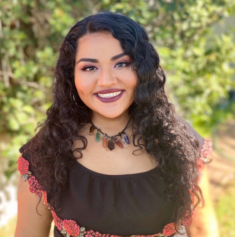 smiling Latina woman in a brown shirt