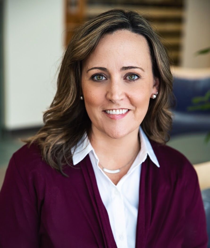 white woman in a dark, berry red sweater with a white button down