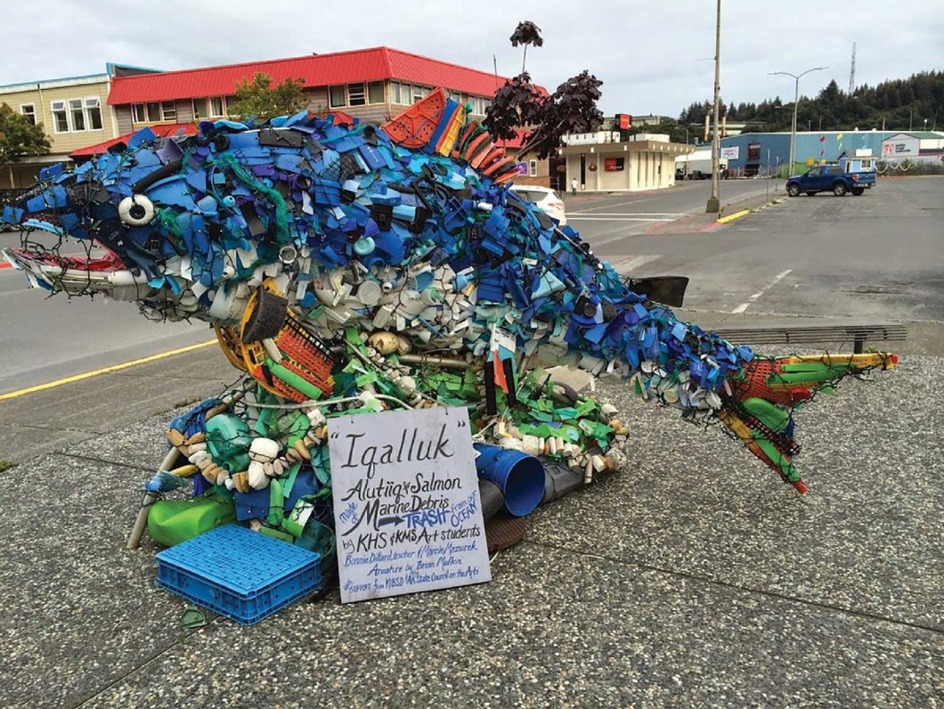 Salmon art made from marine debris with a sign, "Iqalluk" Alutiig Salmon made of marine debris (trash from our ocean) by KHS & KMS Art Students. Bonnie Dillar, Teacher & Marcin Mazurek. Armature by Brian Mulkin."