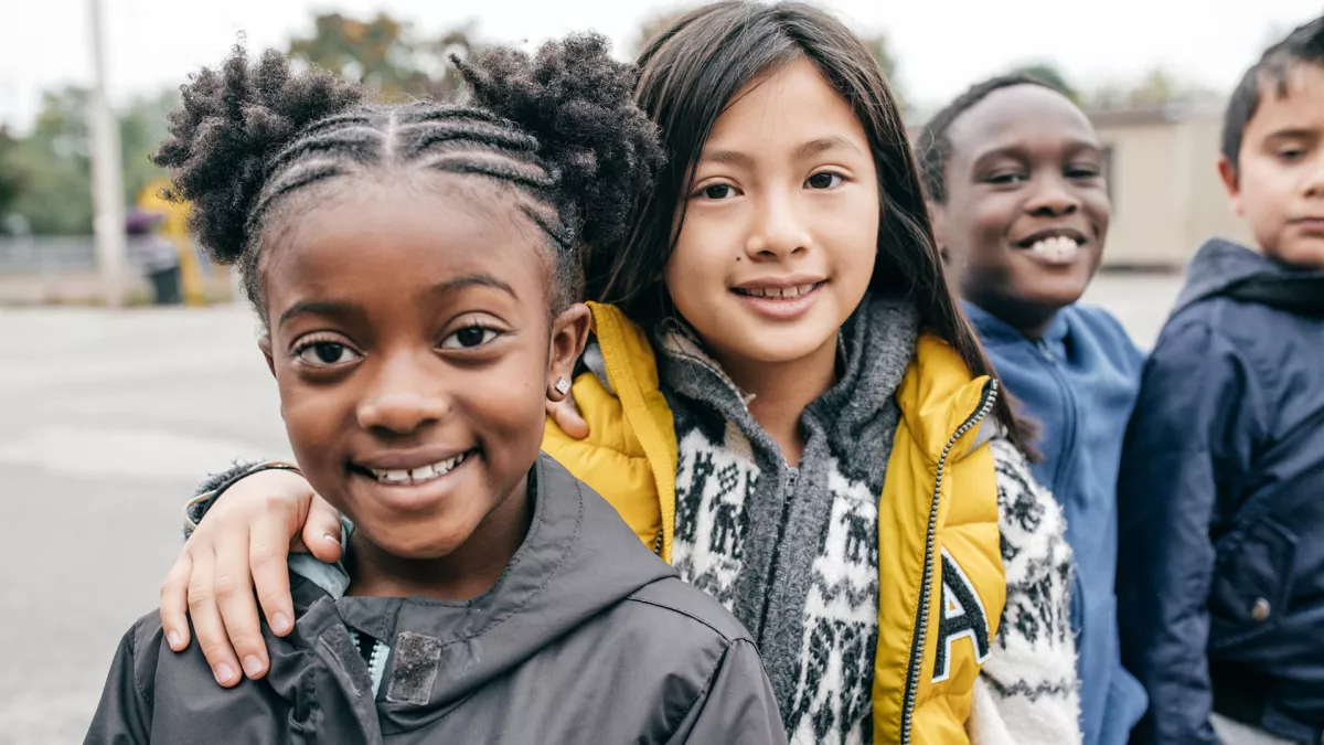 An ethnically diverse group of children smiling at the camera