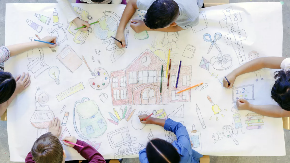 elementary students drawing a mural of school