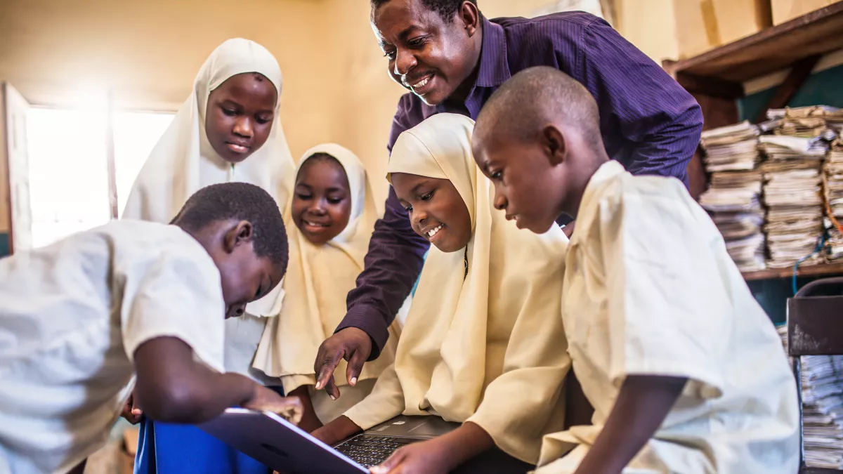 male teacher with students in international classroom