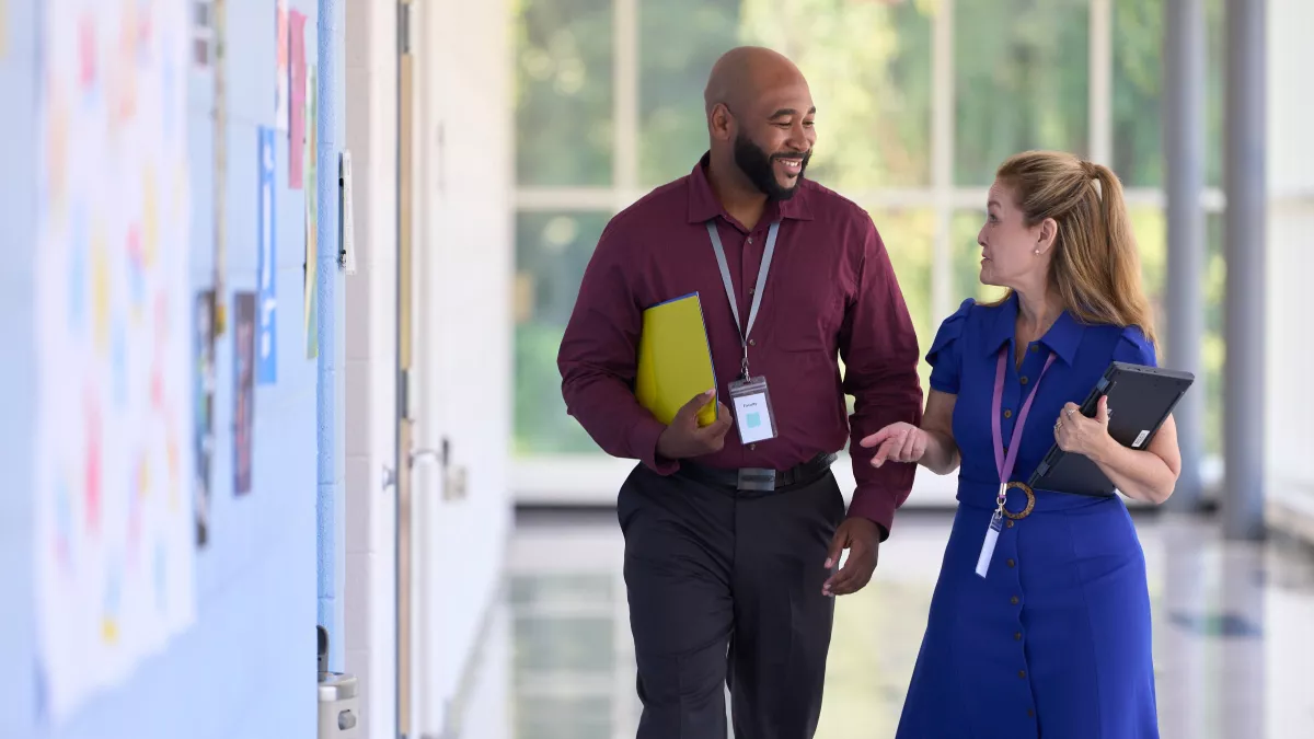 Two teachers walking down hallway