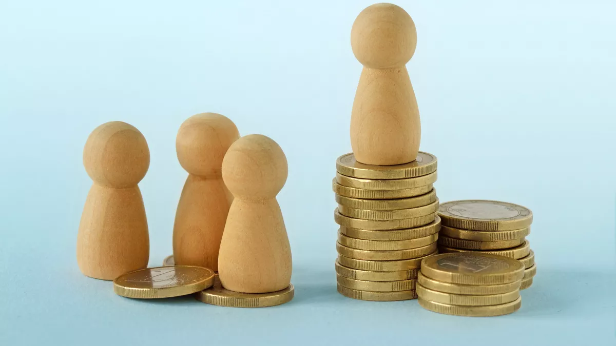 wooden pawn figures with a stack of coins