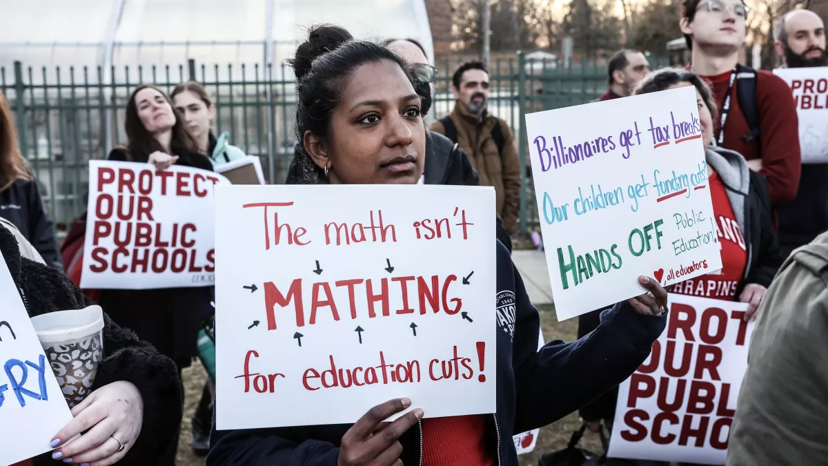 Protesters carry signs advocating for more funding for schools