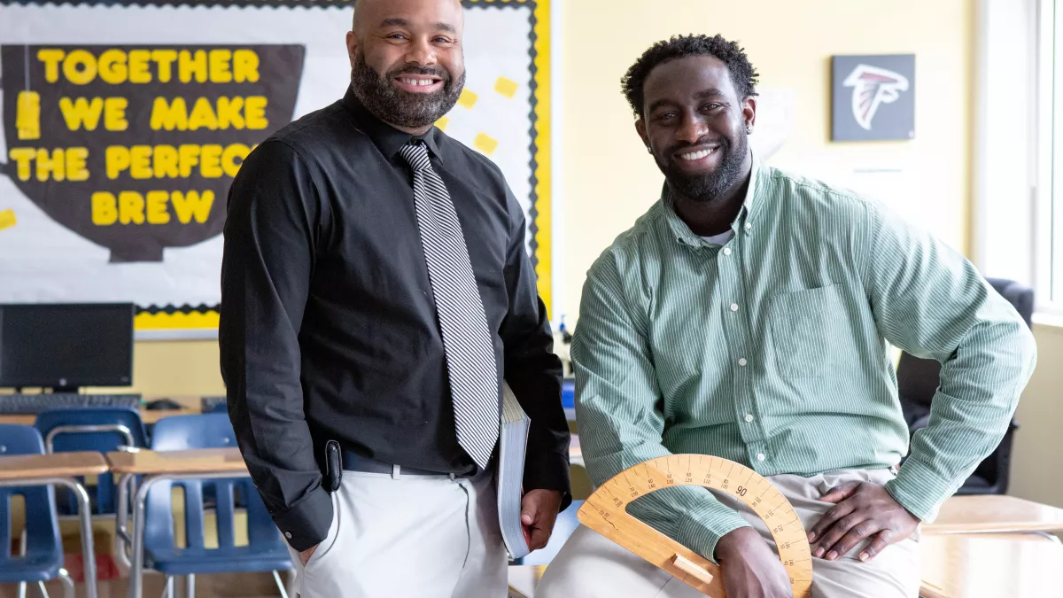 Two teachers spend their break together and smile at the camera.