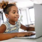 elementary age girl working on laptop