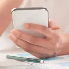 hand holding a white smartphone