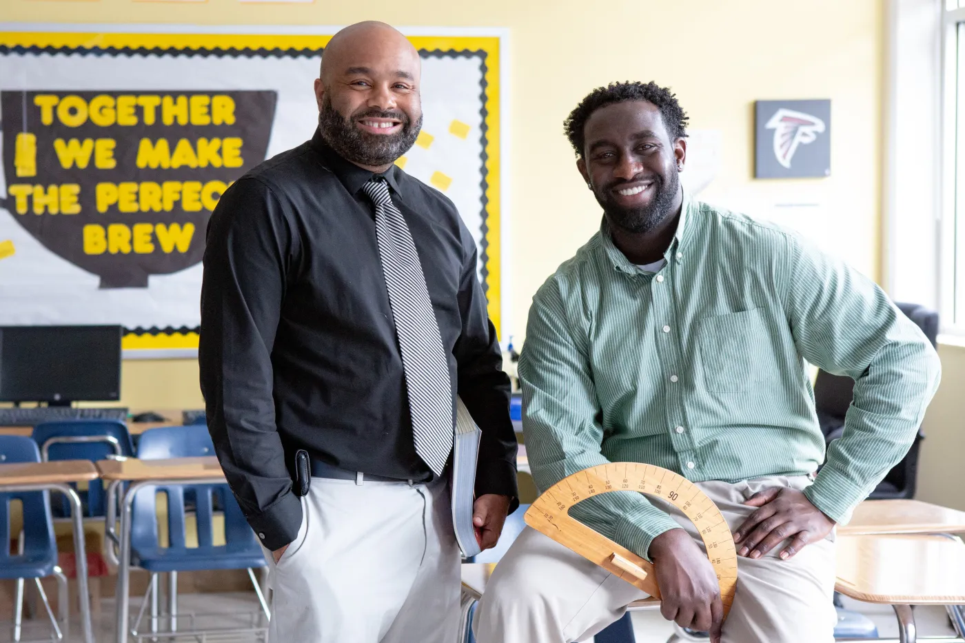Two teachers spend their break together and smile at the camera.