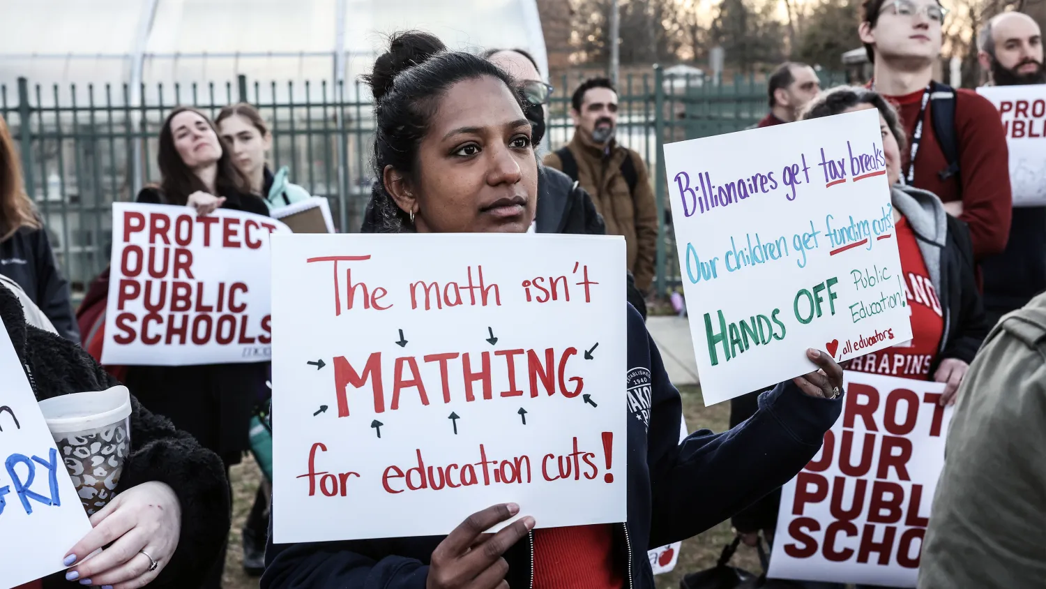 Protesters carry signs advocating for more funding for schools