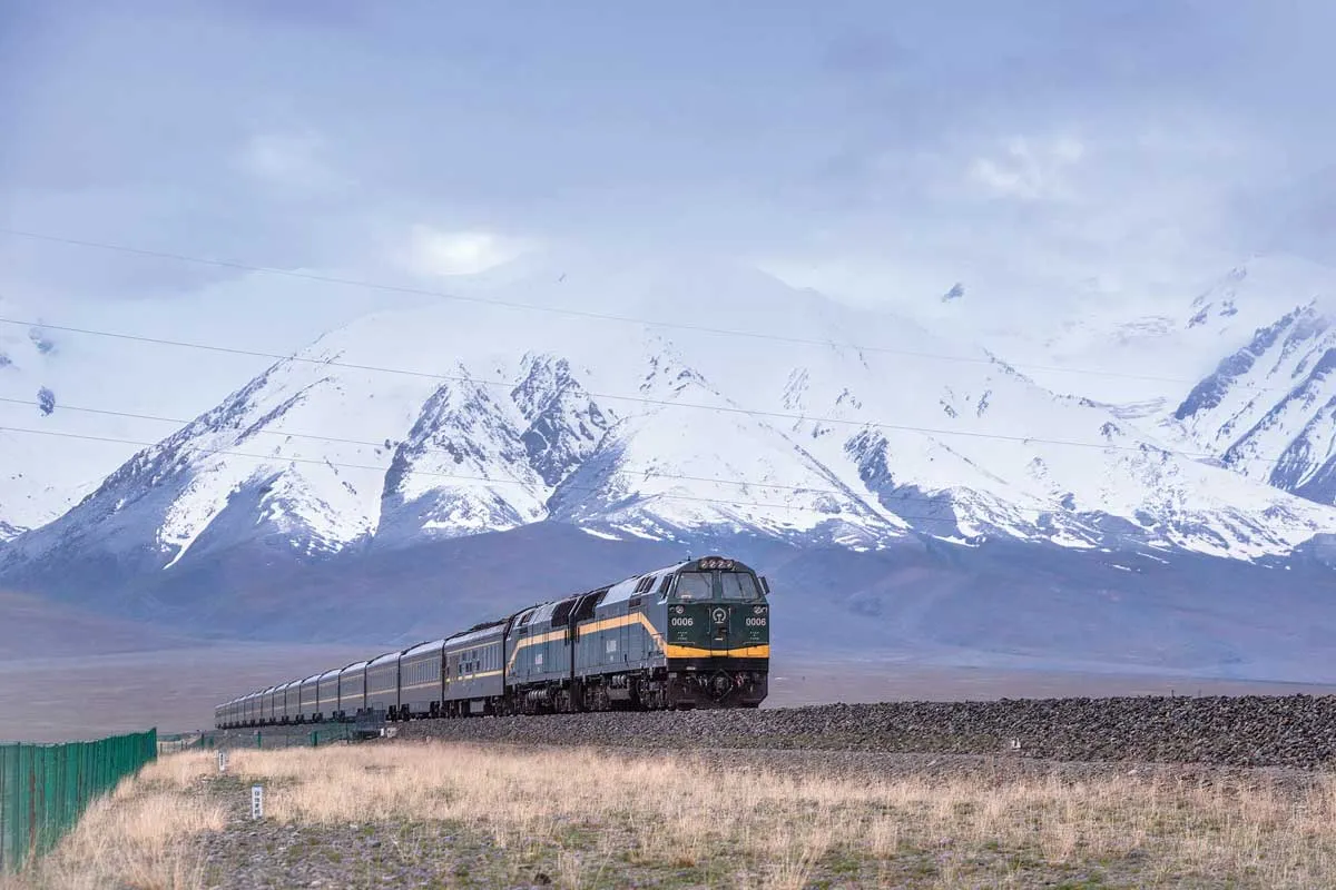 Train with the Himalayan Mountains in the background.