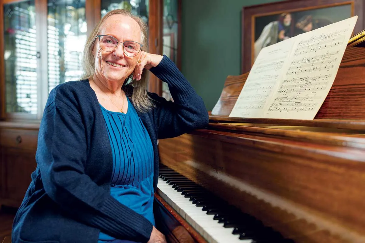 Former Utah music teacher Debbie Green sitting at her piano.