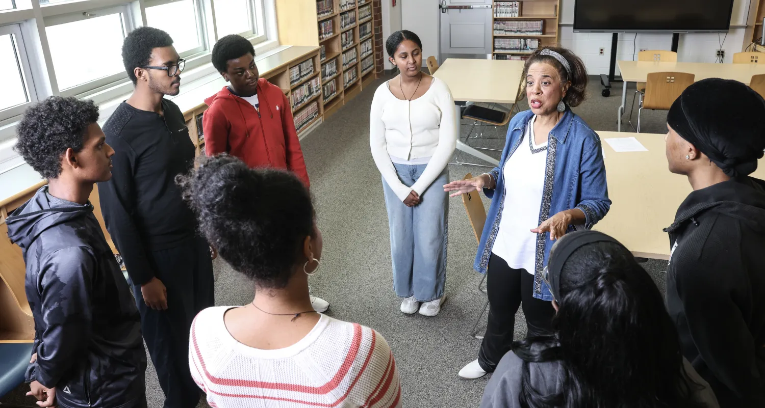 Teacher surrounded by students in school library