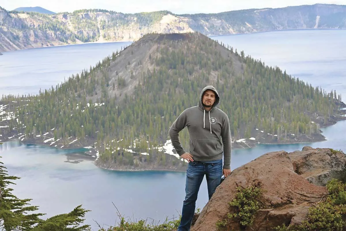 Joseph Hantho with the background of a mountain island in a lake.