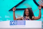 ESP of the Year Pamella Johnson raises her arms as she addressed the 2023 NEA Representative Assembly