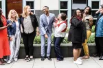 Nine educators stand outside the NEA headquarters building in Washington, DC talking