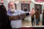 Mike Ragan dancing the tango with his partner in a dance studio with a mirror in the background.