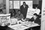 Black and white image of a group of men and woman preparing boycott signs.