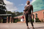 NCAE head custodian Patricia Crews outside of a school holding a bullhorn.