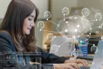 A woman working on a laptop displaying a brain shape surrounded by artificial intelligence icons.