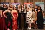 A group of people dressed in formal attire pose for a photo.