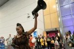A woman holding a megaphone stands in the middle of a supportive crozwd. 