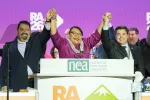 NEA's three officers stand with hands raised on RA stage