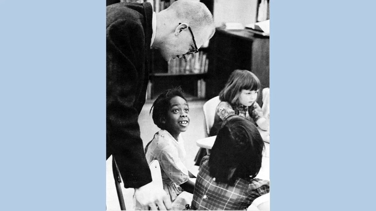 Teacher interacts with elementary students in 1950s classroom