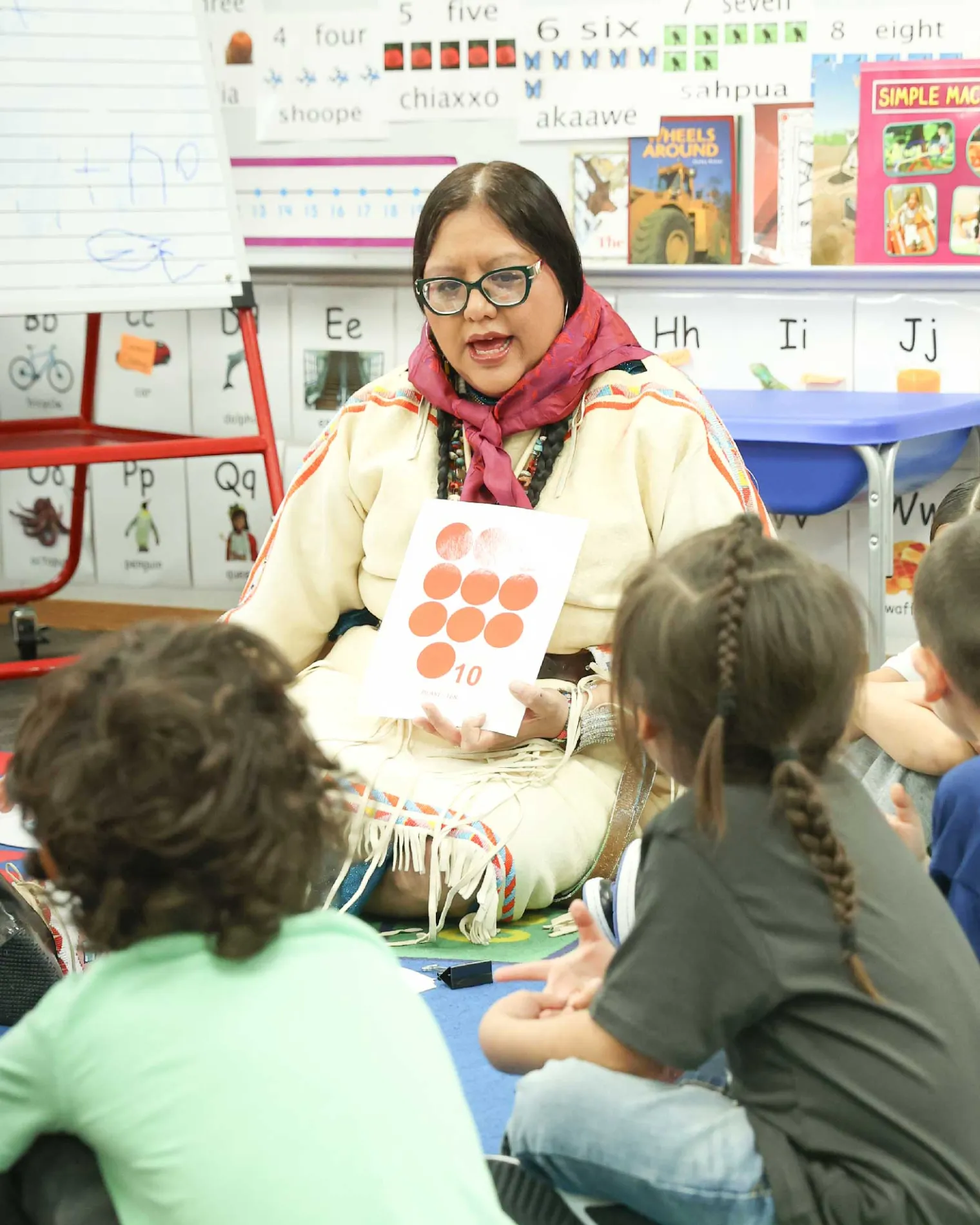 Lucy Real Bird sitting on the floor with students while going over a lesson