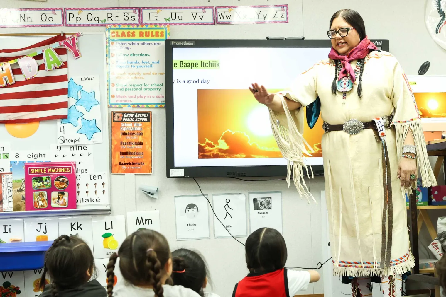 Lucy Real Bird hovering her hands over her students.