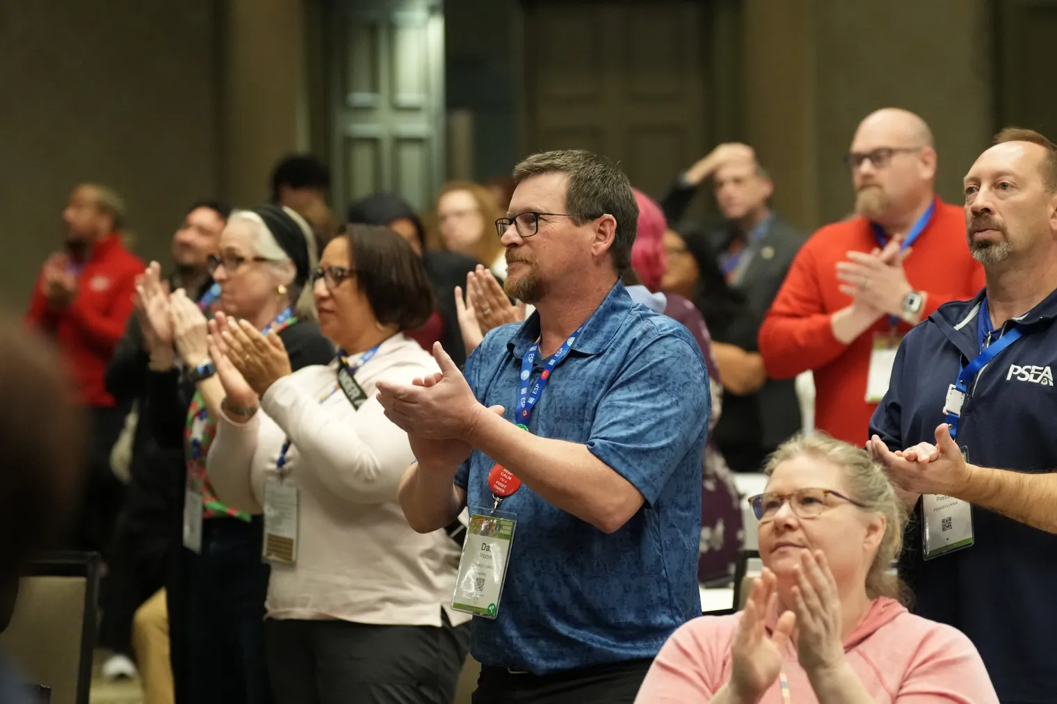 a group of people clapping in a conference audience