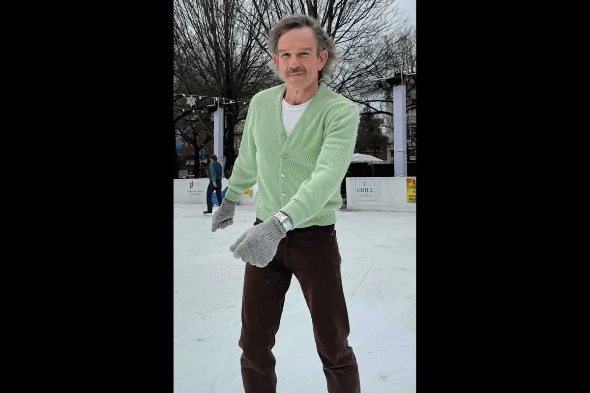 Mr. Ward wearing a lime green sweater and black pants outside in the snow.