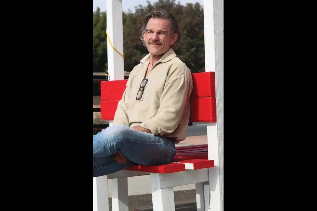 Mr. Ward sitting on a red bench.