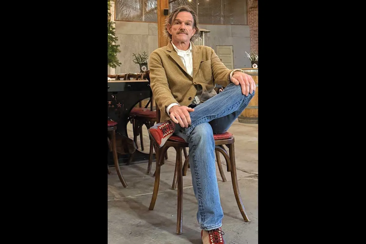 Mr. Ward wearing a light brown jacket and jeans.