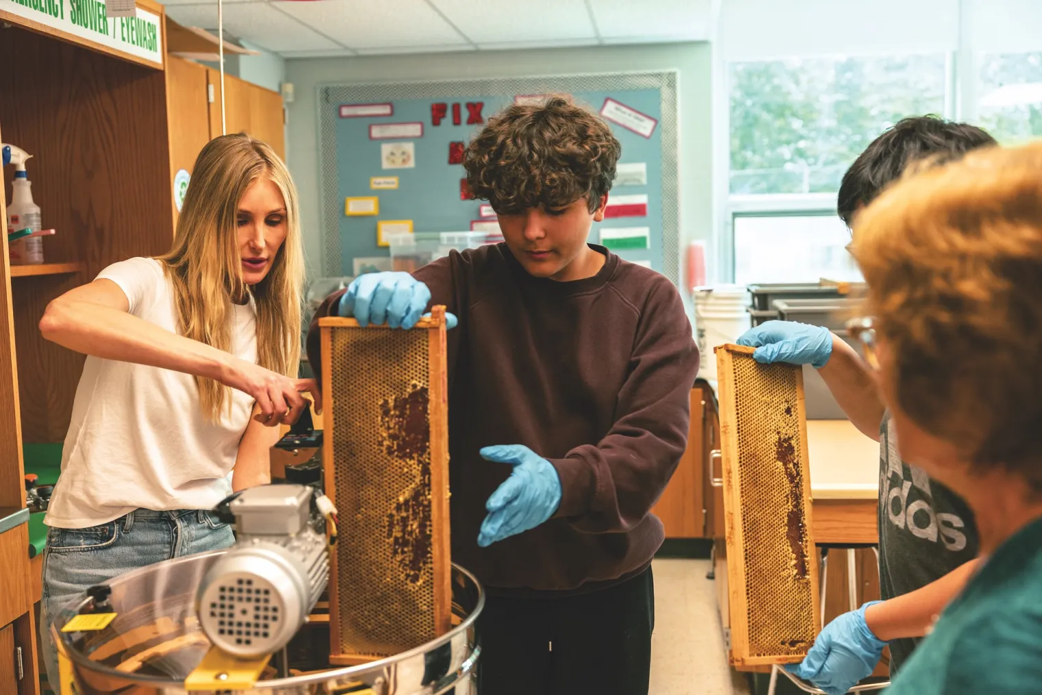 Kristen Lindstrom and students with honey-filled bee frame