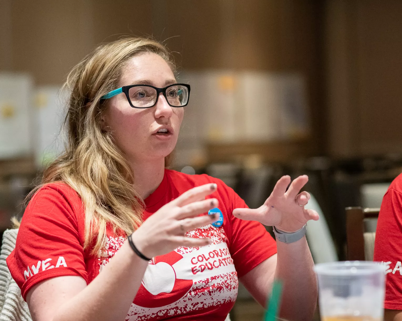 Colorado educator in red shirt speaking