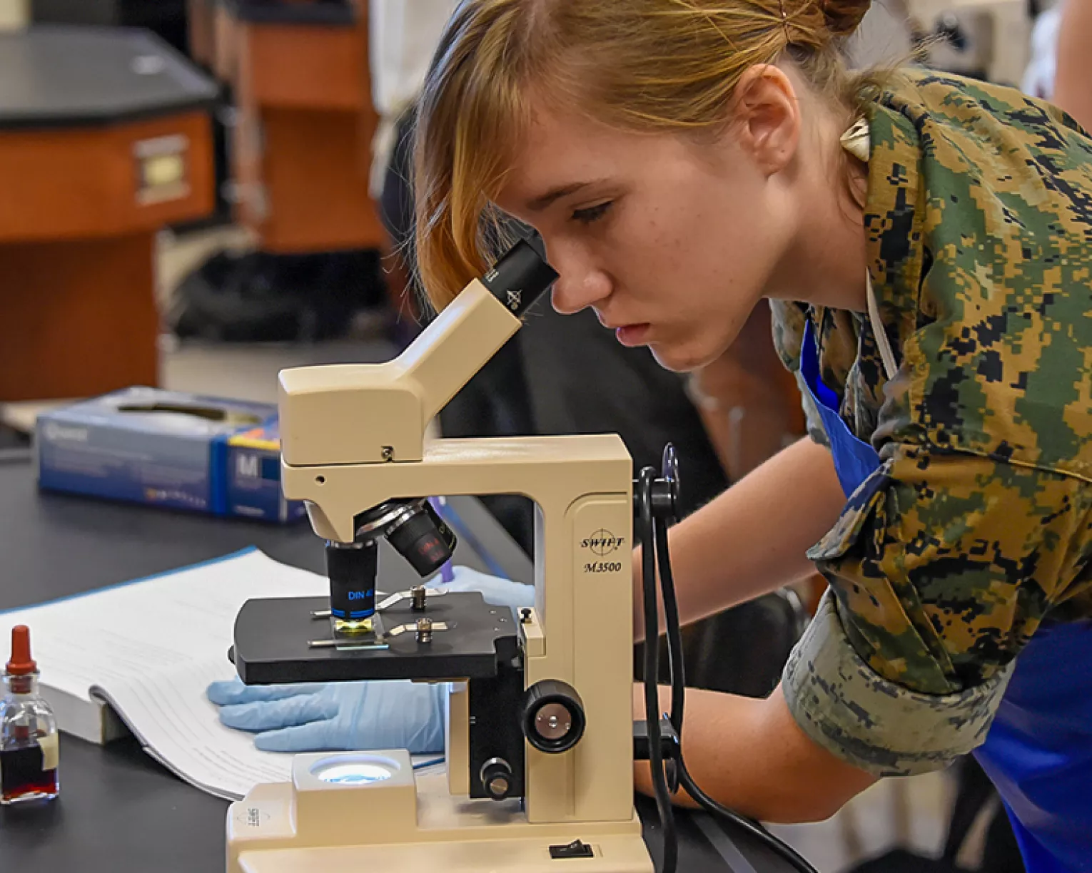 Student looking through microscope