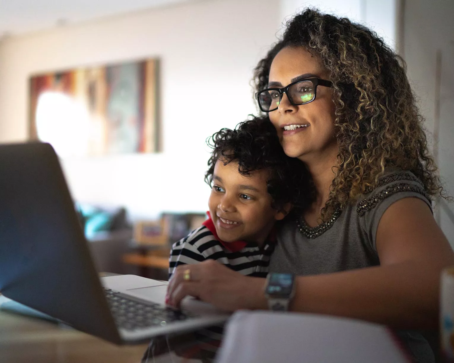 A woman and her son use a laptop together