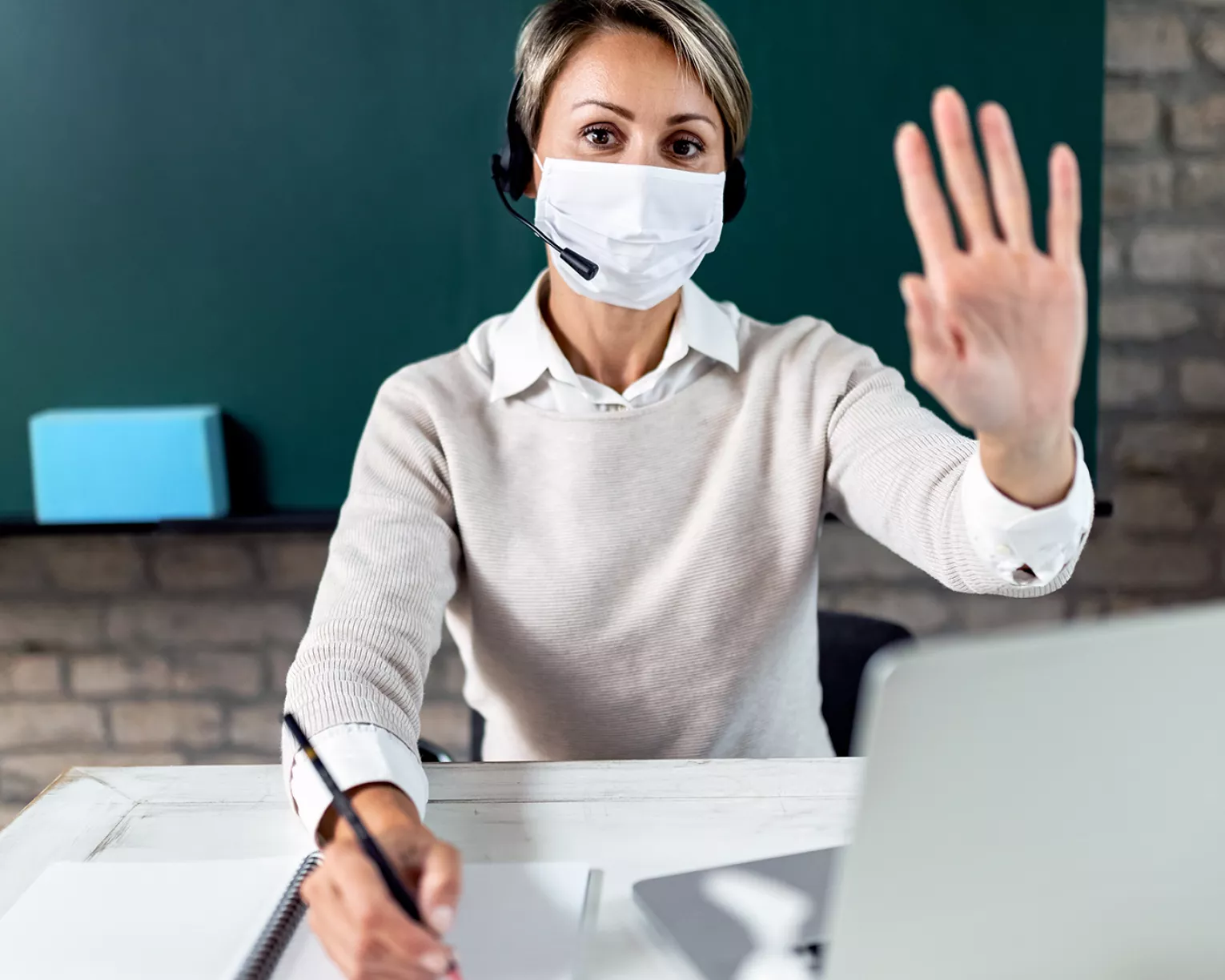 teacher with mask at her desk