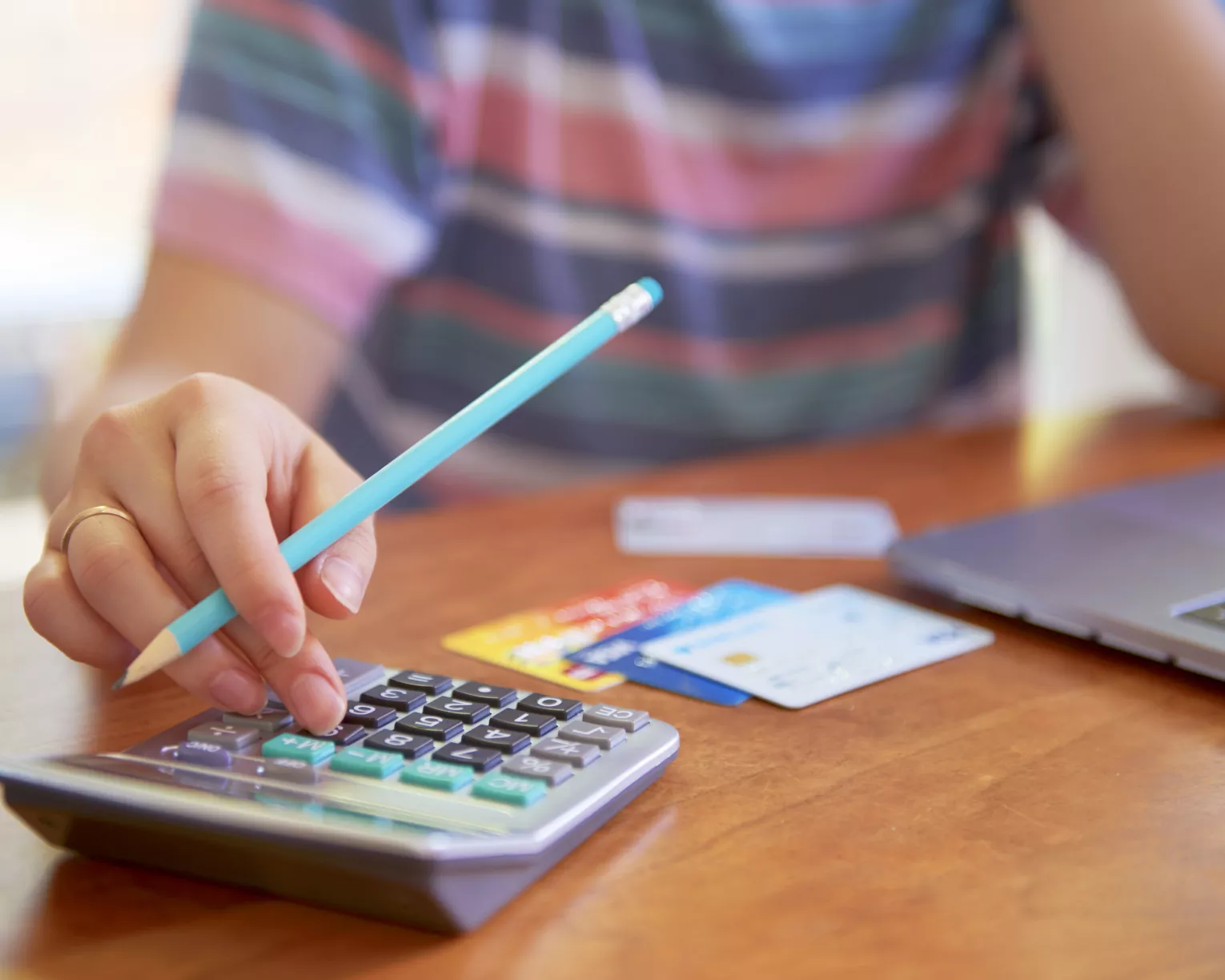 Person with a calculator and credit cards deals with financial issues.