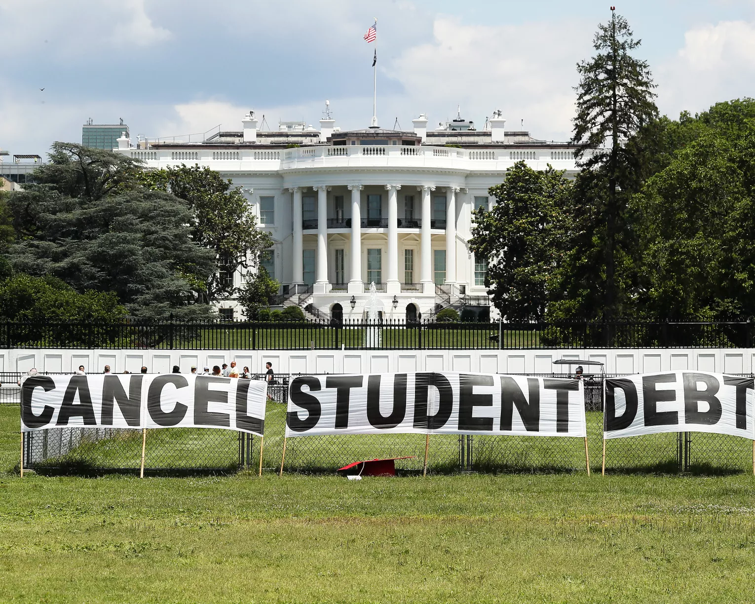 Signs saying cancel student debt outside the White House.