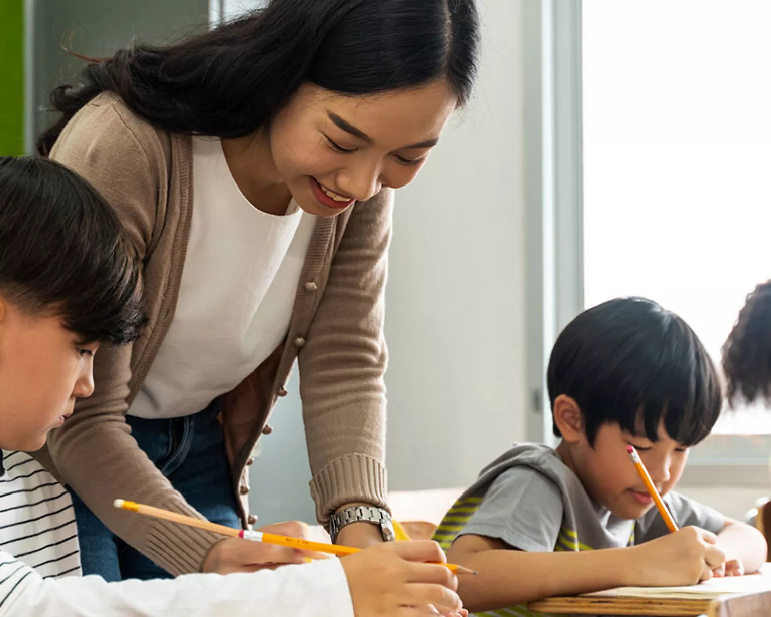 asian teacher working with students in class