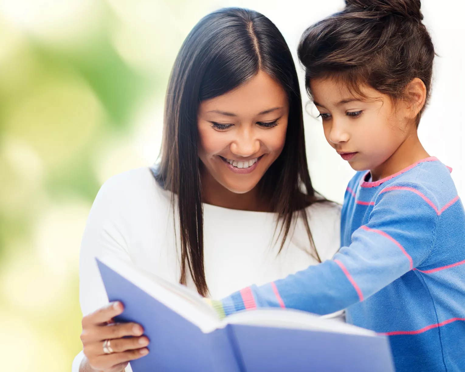 Mom and daughter reading a book together
