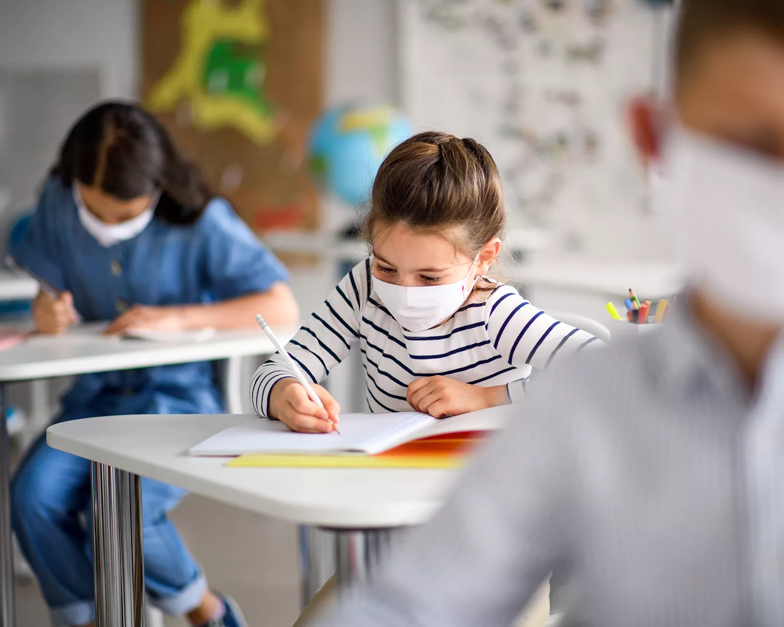 Children wearing masks working at desks