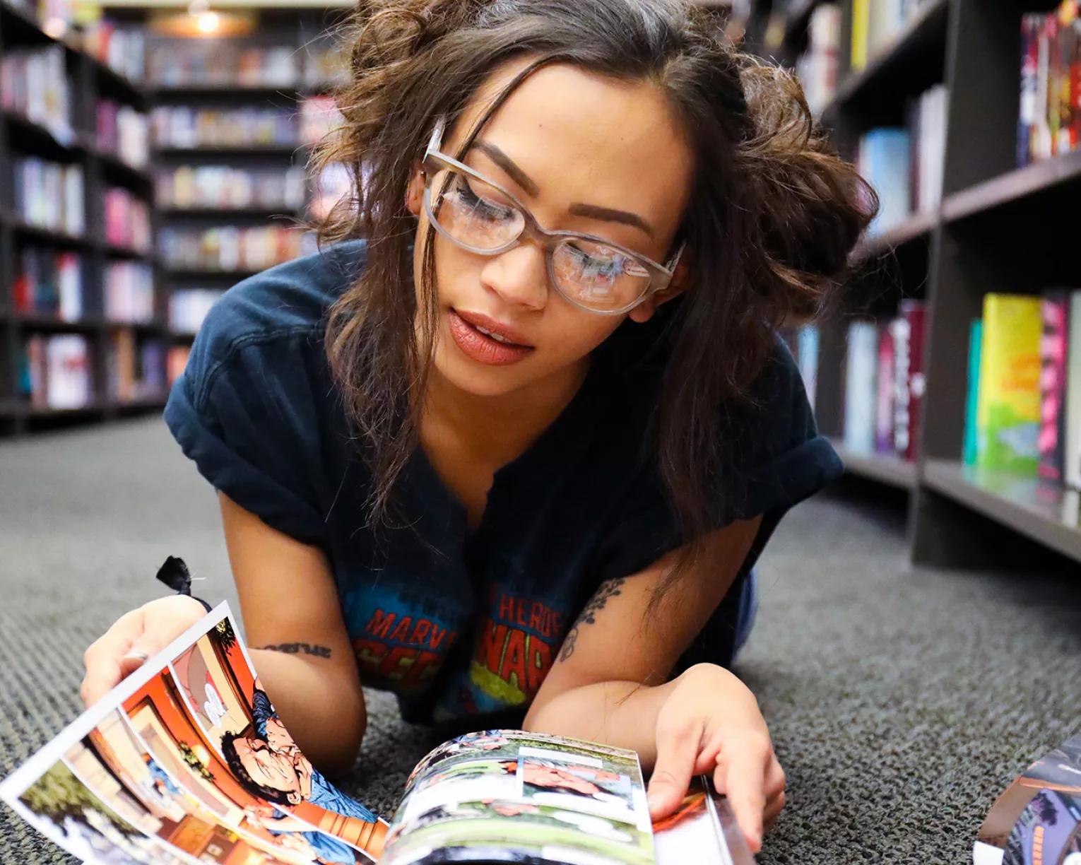 High school student reading graphic novel in the library