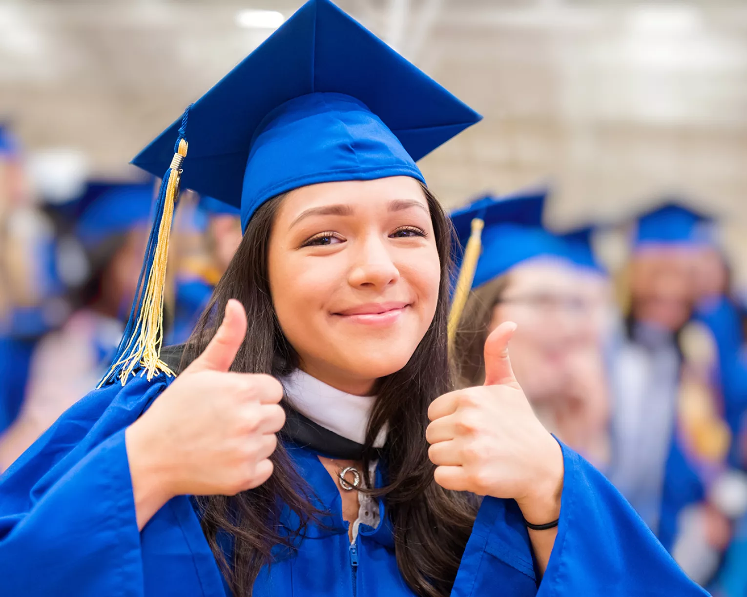 female high school graduate in cap and gown