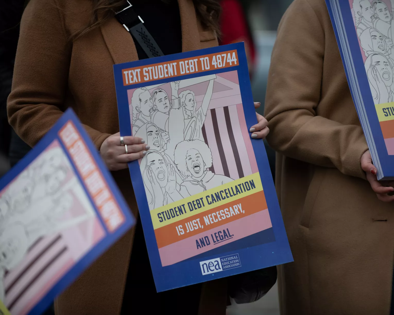 Woman holds student debt advocacy sign.